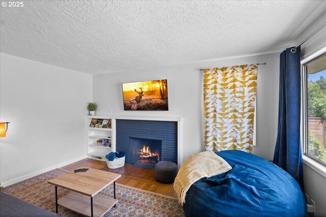1637 Camino Dr, Forest Grove, OR 97116 - living area with a textured ceiling, healthy amount of natural light, wood finished floors, a brick fireplace, and baseboards