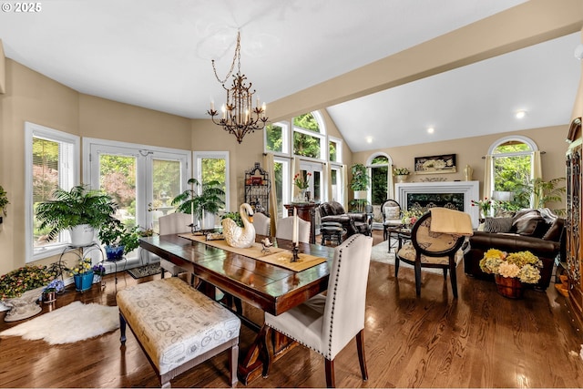3420 SE 144th Ct, Vancouver, WA 98683 - dining space featuring wood finished floors, a chandelier, a premium fireplace, and vaulted ceiling
