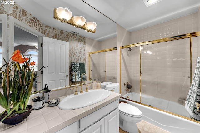 3420 SE 144th Ct, Vancouver, WA 98683 - bathroom featuring wallpapered walls, toilet, vanity, and enclosed tub / shower combo