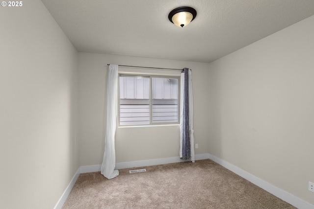 spare room featuring carpet floors and a textured ceiling