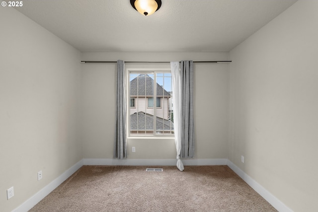 unfurnished room featuring a textured ceiling and carpet flooring