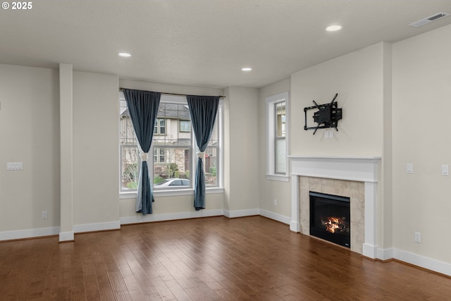 unfurnished living room with dark wood-type flooring and a fireplace