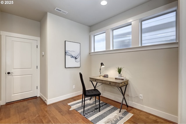 office space featuring visible vents, baseboards, and wood finished floors