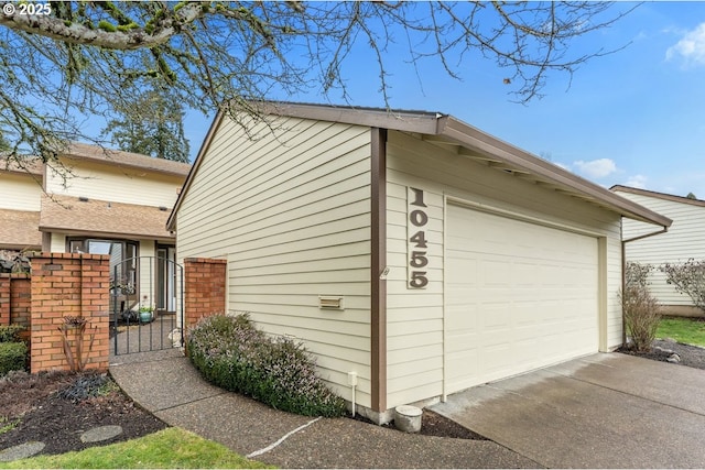 view of home's exterior featuring a garage, a gate, and an outdoor structure