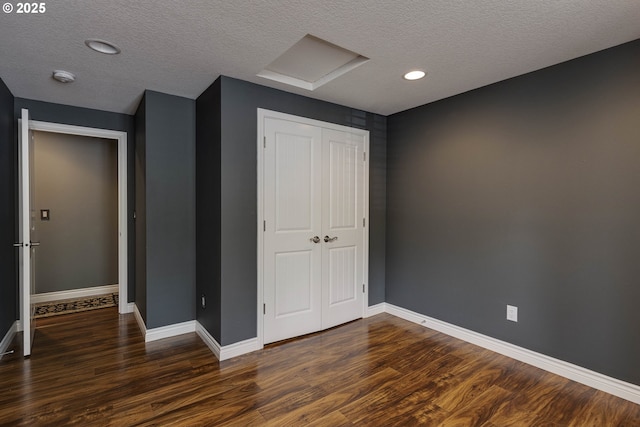 unfurnished bedroom with a closet, wood finished floors, baseboards, recessed lighting, and a textured ceiling