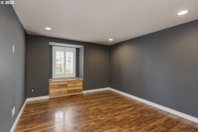 empty room with baseboards, a textured ceiling, recessed lighting, and wood finished floors