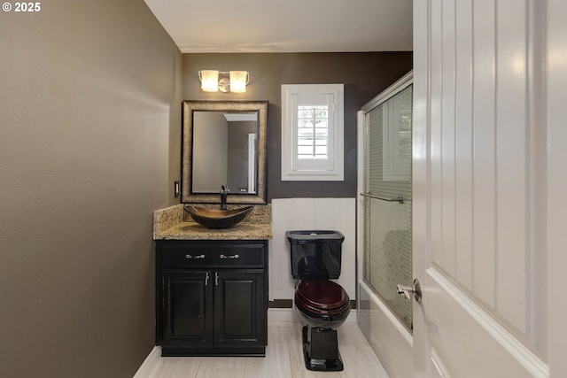 bathroom featuring vanity, baseboards, bathtub / shower combination, and toilet