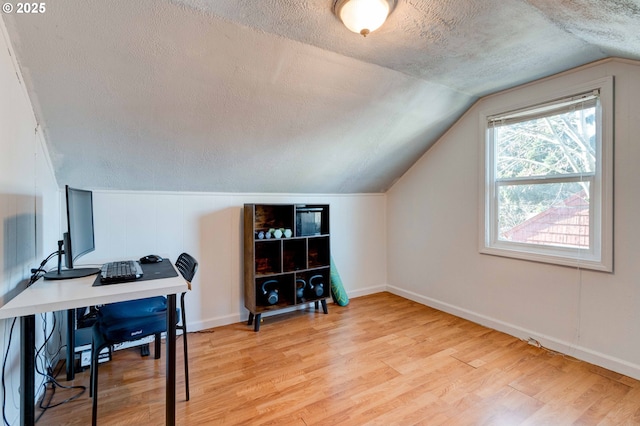 office space with hardwood / wood-style flooring, vaulted ceiling, and a textured ceiling