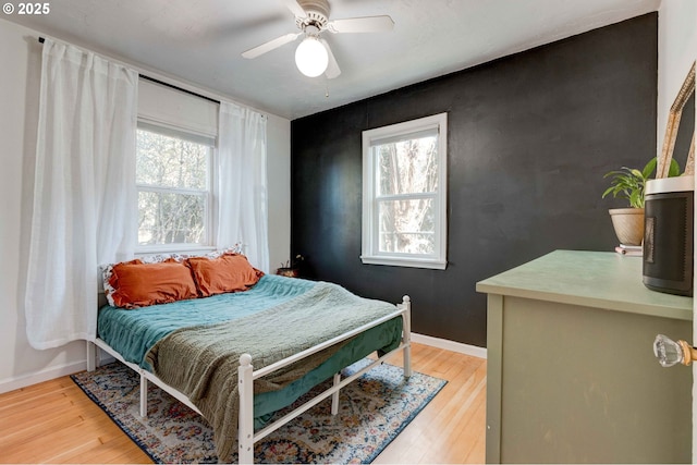 bedroom with ceiling fan, hardwood / wood-style floors, and multiple windows