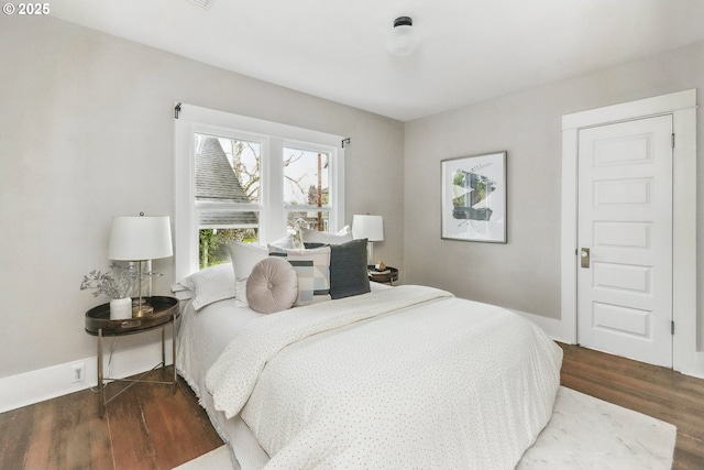 bedroom with wood finished floors and baseboards