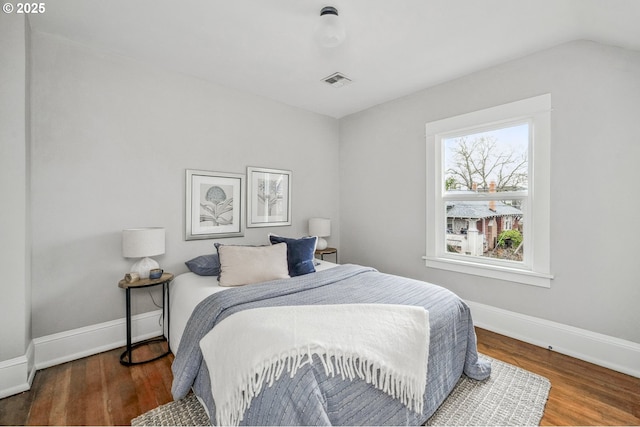 bedroom with visible vents, baseboards, and wood finished floors