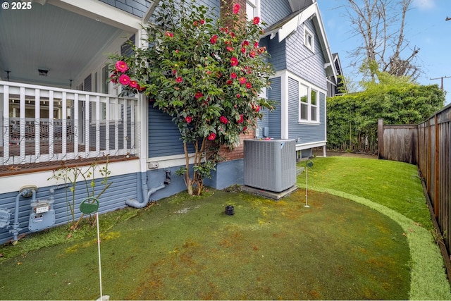 view of side of home with cooling unit and fence