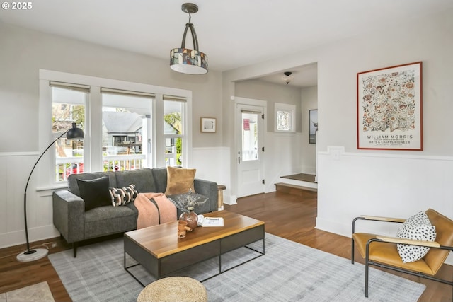 living room with wood finished floors and a wainscoted wall