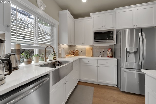 3783 Rockcress Rd, Eugene, OR 97403 - kitchen featuring stainless steel appliances, a sink, white cabinetry, backsplash, and light countertops