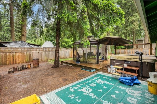 view of swimming pool with a hot tub, a gazebo, a deck, and a fenced backyard