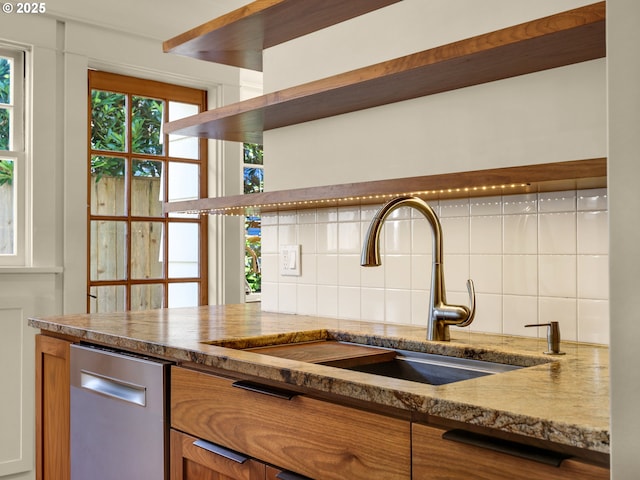 kitchen featuring a sink, backsplash, dishwasher, brown cabinets, and open shelves