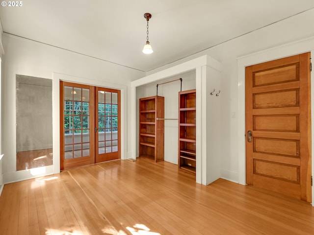 spare room with light wood-style flooring, french doors, and baseboards