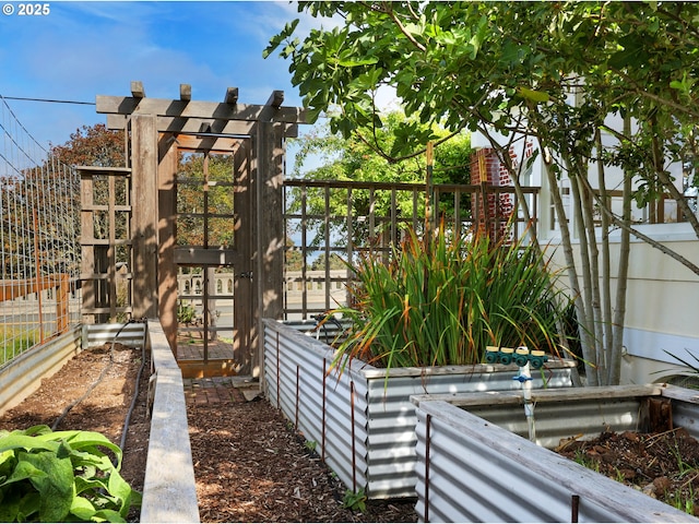 view of home's exterior with fence and a garden