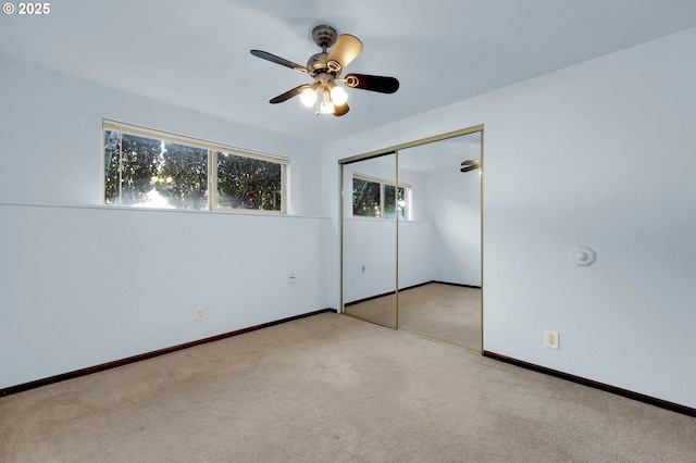 unfurnished bedroom featuring carpet, a closet, multiple windows, and baseboards