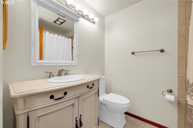 bathroom featuring curtained shower, toilet, vanity, baseboards, and tile patterned floors