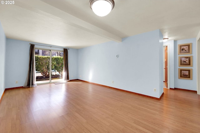 spare room with light wood-type flooring, baseboards, and beam ceiling