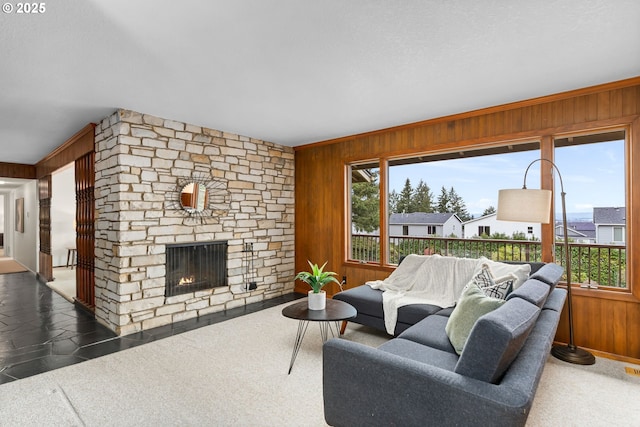 living area featuring wooden walls and a fireplace