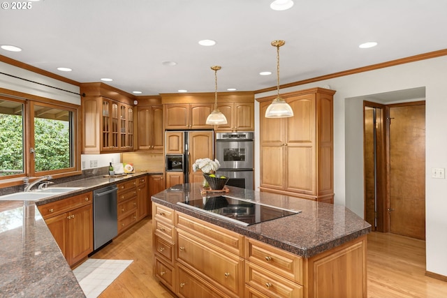 kitchen with light wood-style floors, glass insert cabinets, stainless steel appliances, and a sink