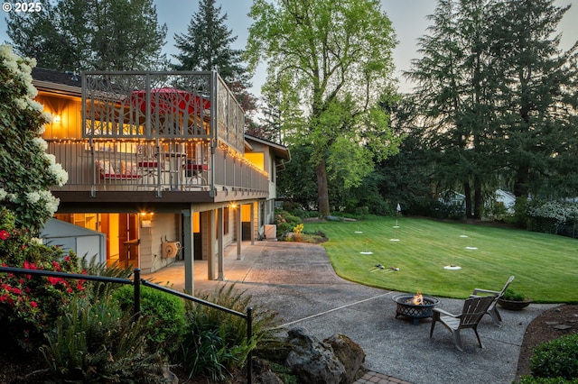 view of yard with a fire pit, a patio area, and a wooden deck