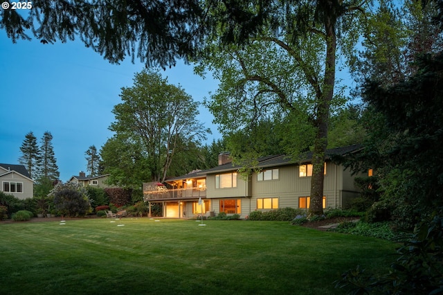 rear view of house featuring a yard and a chimney