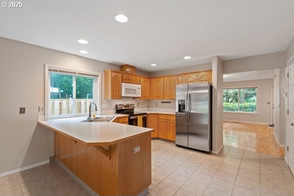 17504 SE 16th Cir, Vancouver, WA 98683 - kitchen featuring appliances with stainless steel finishes, a sink, a peninsula, light countertops, and baseboards
