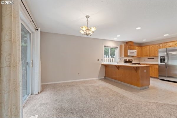17504 SE 16th Cir, Vancouver, WA 98683 - kitchen with stainless steel fridge with ice dispenser, white microwave, stove, a chandelier, and light countertops