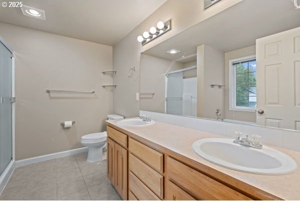 17504 SE 16th Cir, Vancouver, WA 98683 - bathroom with baseboards, a stall shower, double vanity, tile patterned flooring, and toilet