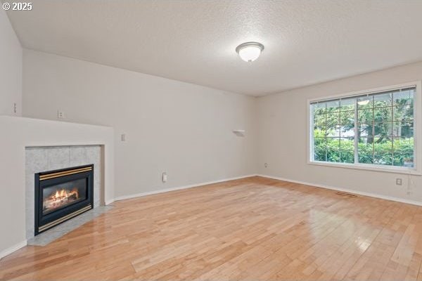 17504 SE 16th Cir, Vancouver, WA 98683 - unfurnished living room with light wood-style floors, a tile fireplace, and baseboards
