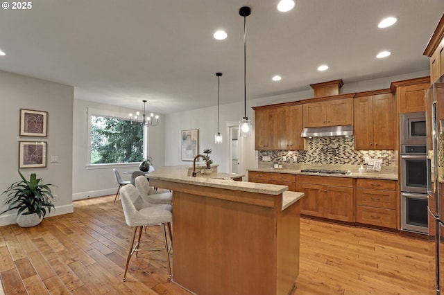 1734 NW Saltzman Rd, Portland, OR 97229 - kitchen featuring light wood-style flooring, brown cabinets, stainless steel appliances, baseboards, and recessed lighting