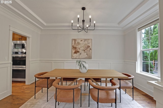 1734 NW Saltzman Rd, Portland, OR 97229 - dining area with a tray ceiling, a chandelier, light wood-style flooring, a wainscoted wall, and ornamental molding