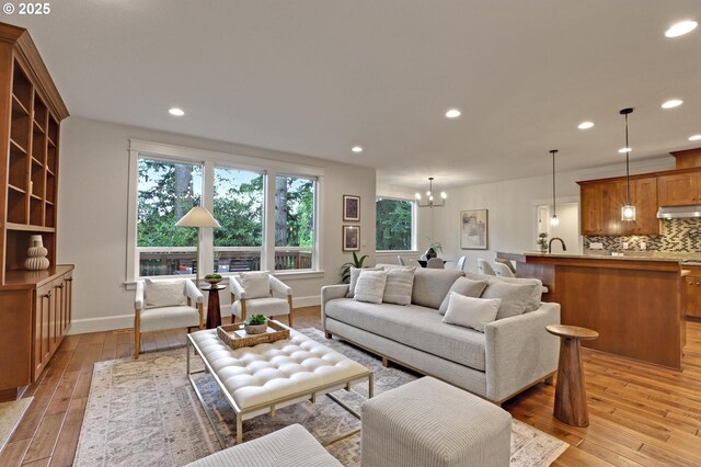 1734 NW Saltzman Rd, Portland, OR 97229 - living room featuring light wood-style flooring, a chandelier, recessed lighting, and baseboards