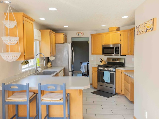 3135 SE 26th St, Gresham, OR 97080 - kitchen with appliances with stainless steel finishes, light countertops, a peninsula, recessed lighting, and a breakfast bar area