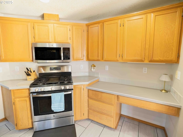 3135 SE 26th St, Gresham, OR 97080 - kitchen with appliances with stainless steel finishes, light countertops, light tile patterned floors, and light brown cabinets