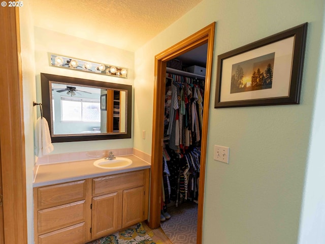 3135 SE 26th St, Gresham, OR 97080 - bathroom featuring vanity, a walk in closet, and a textured ceiling