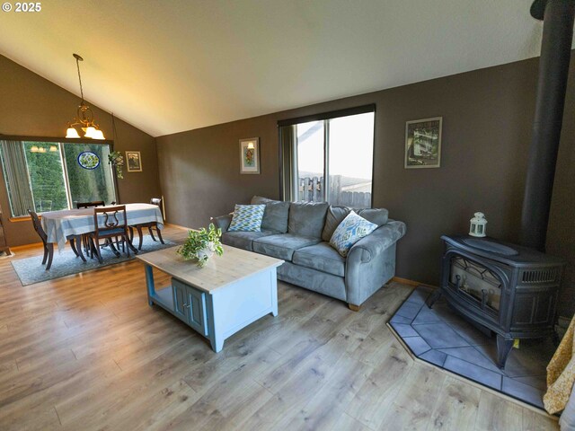 3135 SE 26th St, Gresham, OR 97080 - living room featuring lofted ceiling, a wood stove, plenty of natural light, a chandelier, and light wood-type flooring