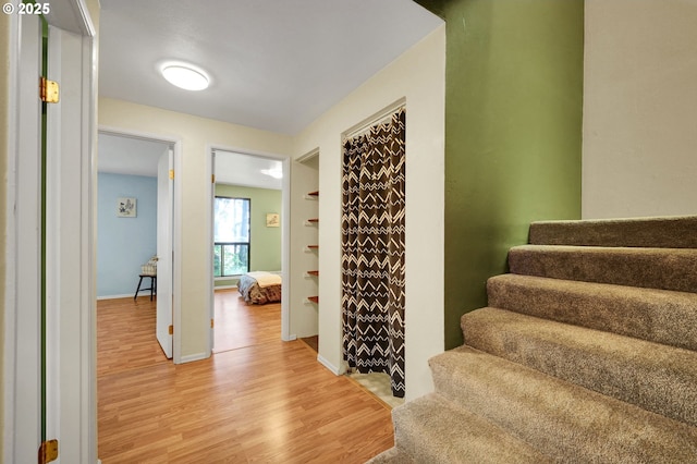 stairway with baseboards and wood finished floors