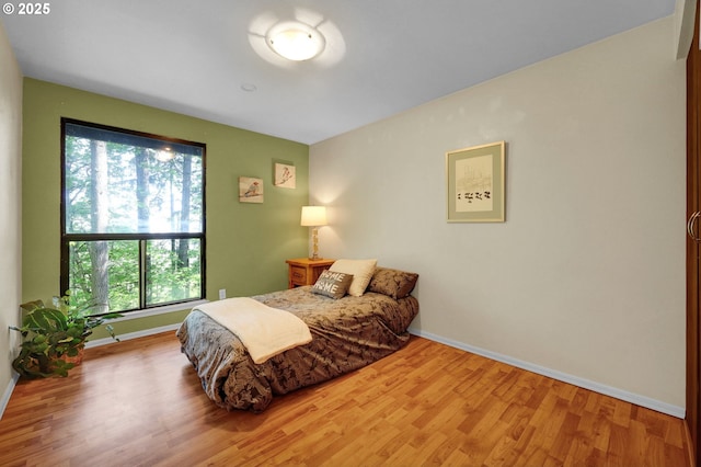 bedroom featuring baseboards and wood finished floors