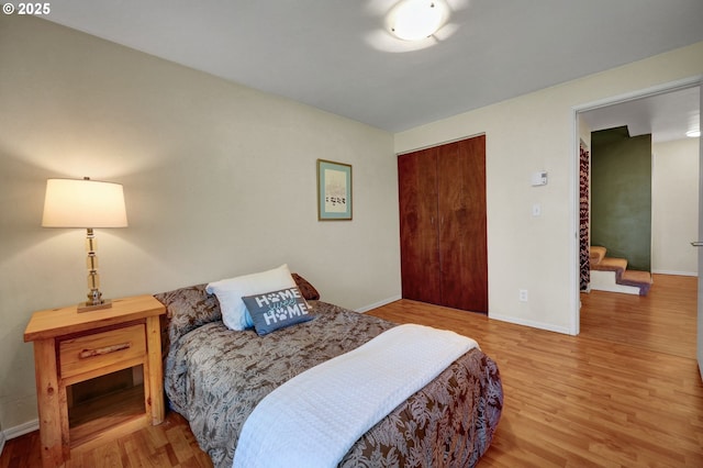 bedroom featuring baseboards, a closet, and wood finished floors