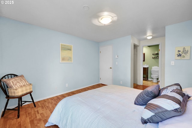 bedroom with wood finished floors and ensuite bathroom