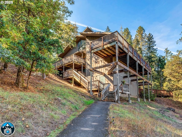view of property exterior featuring stairs and a wooden deck