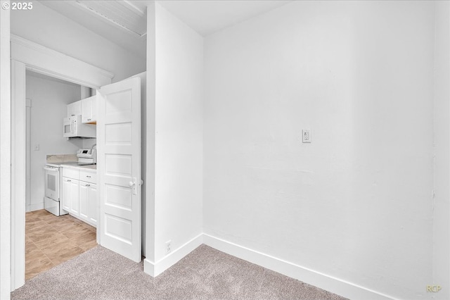 hallway featuring light carpet and baseboards