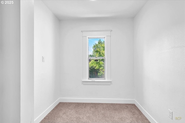 carpeted empty room featuring baseboards