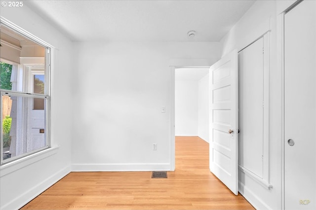 empty room with light wood finished floors and baseboards