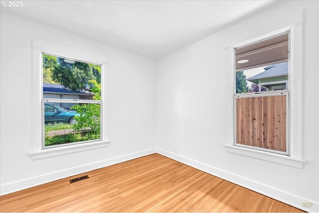 unfurnished room with light wood-type flooring and baseboards