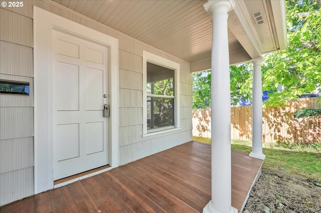 property entrance featuring a porch and fence